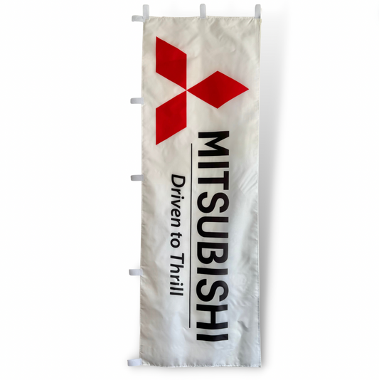 A rectangular Mitsubishi flag featuring the company's logo in red on a white background with the text 'MITSUBISHI DRIVEN TO THRILL' below the logo.