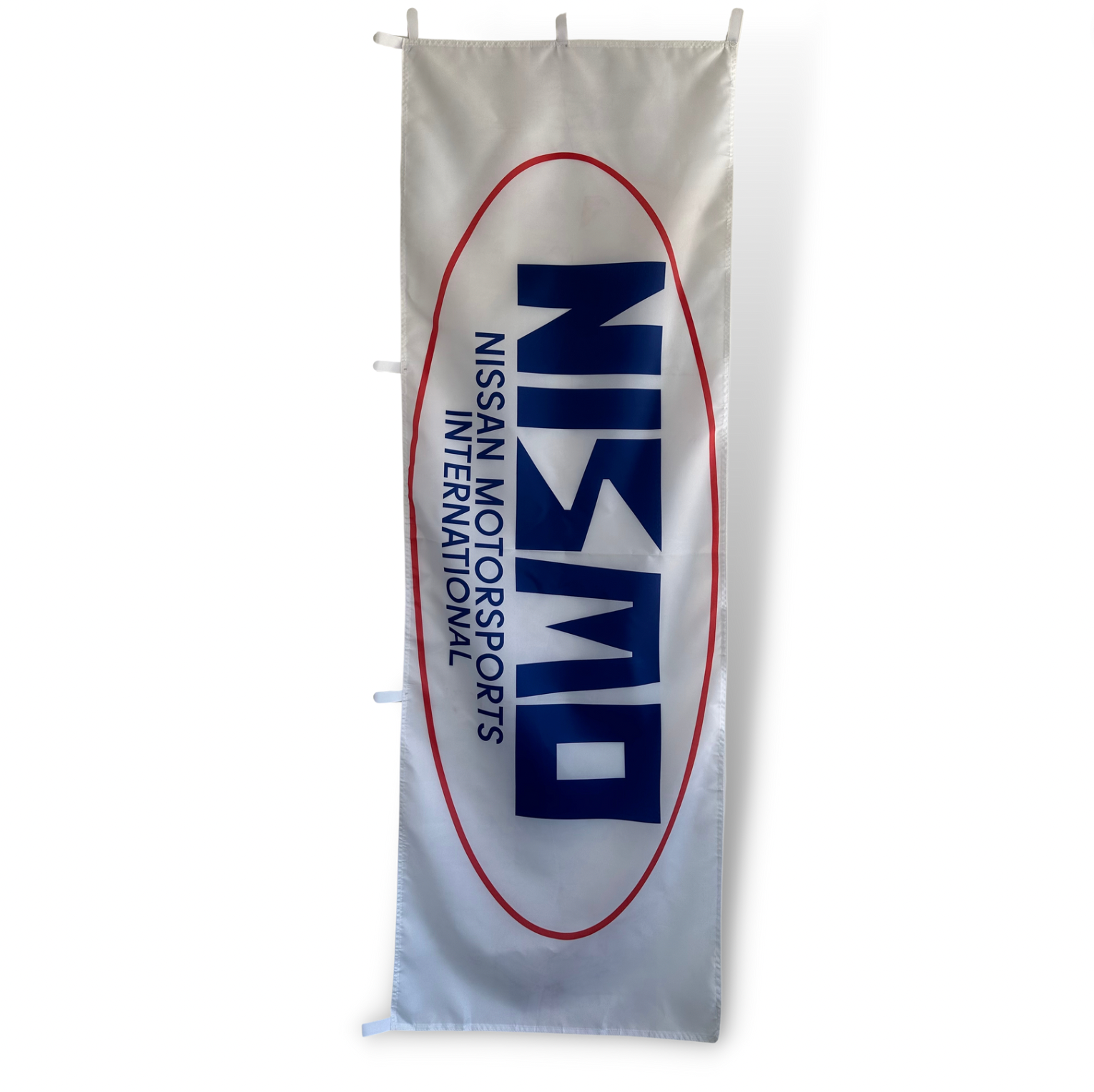A rectangular flag with a white background featuring the Nismo International Motorsports logo in blue and red.