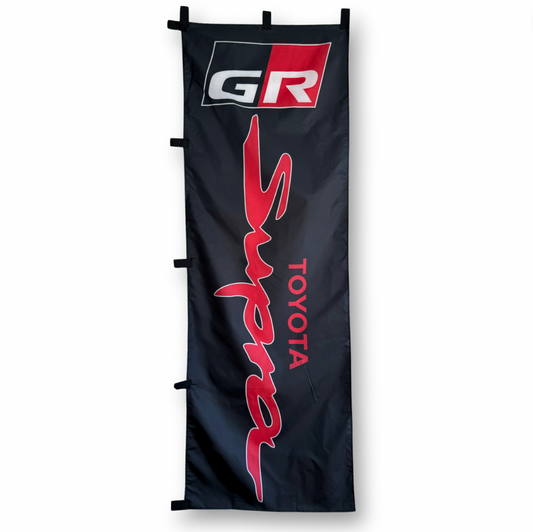A black flag with the red and white Supra brand logo and the word 'TOYOTA' below it.