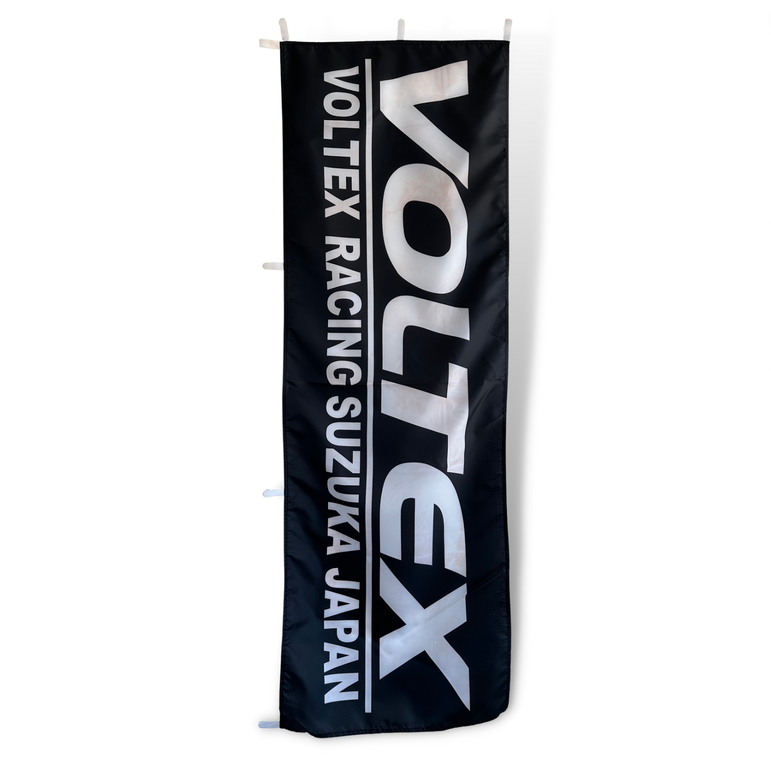 A rectangular black flag with the Voltex Racing Suzuka Japan text in white.