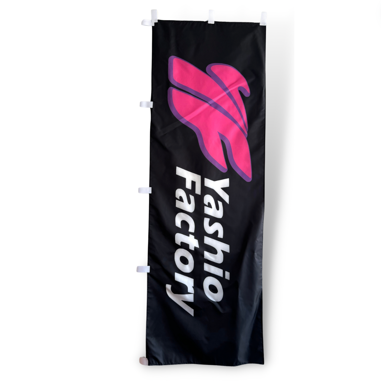 A rectangular flag with a black background featuring a pink graphic and the text 'YASHIO FACTORY' in white.